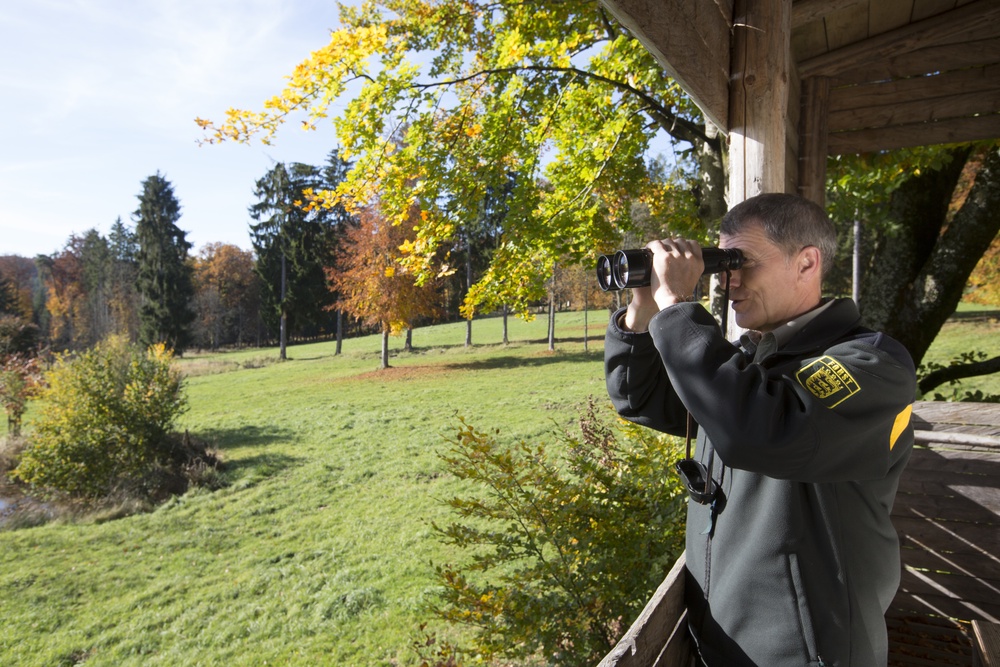 Eine Person schaut mit einem Fernglas in die Weite