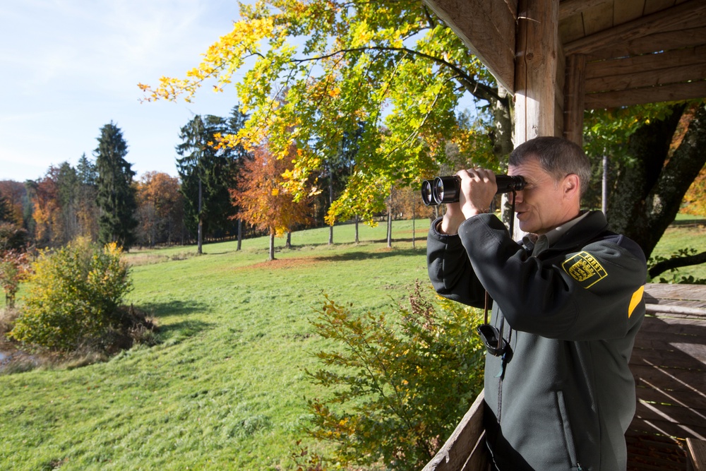 Eine Person schaut mit einem Fernglas in die Weite